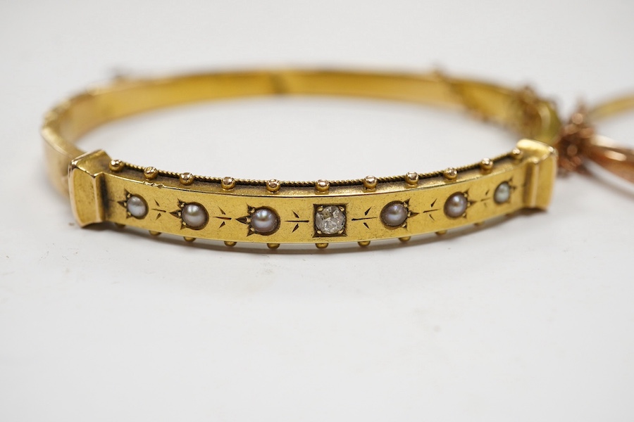 An Edwardian yellow metal, diamond and seed pearl set hinged bangle and one other late Victorian engraved 9ct gold hinged bangle, both a.f., gross weight 14.6 grams. Condition - poor